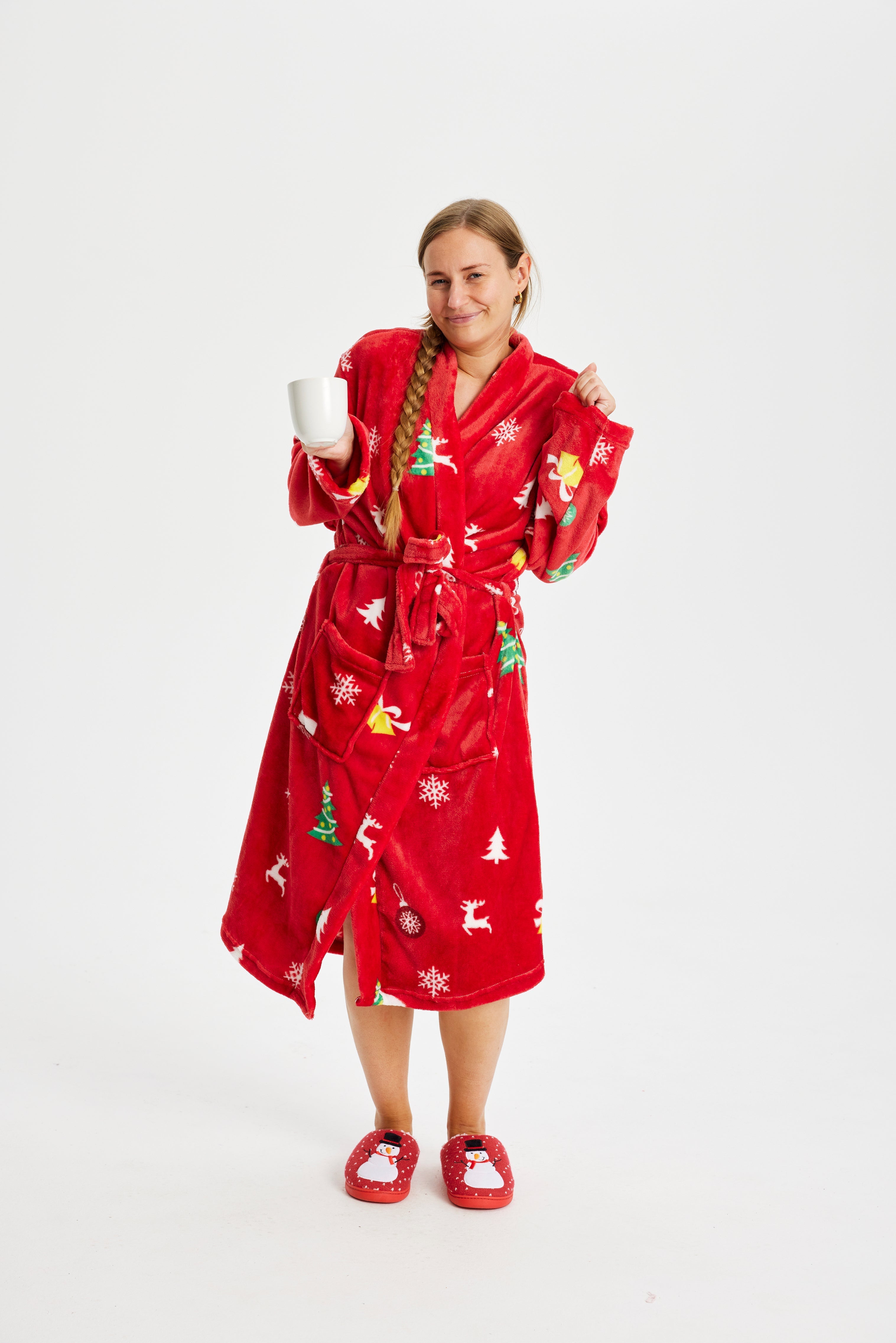 Eine Frau in einem roten Weihnachtsbademantel mit Weihnachtsmotiv.