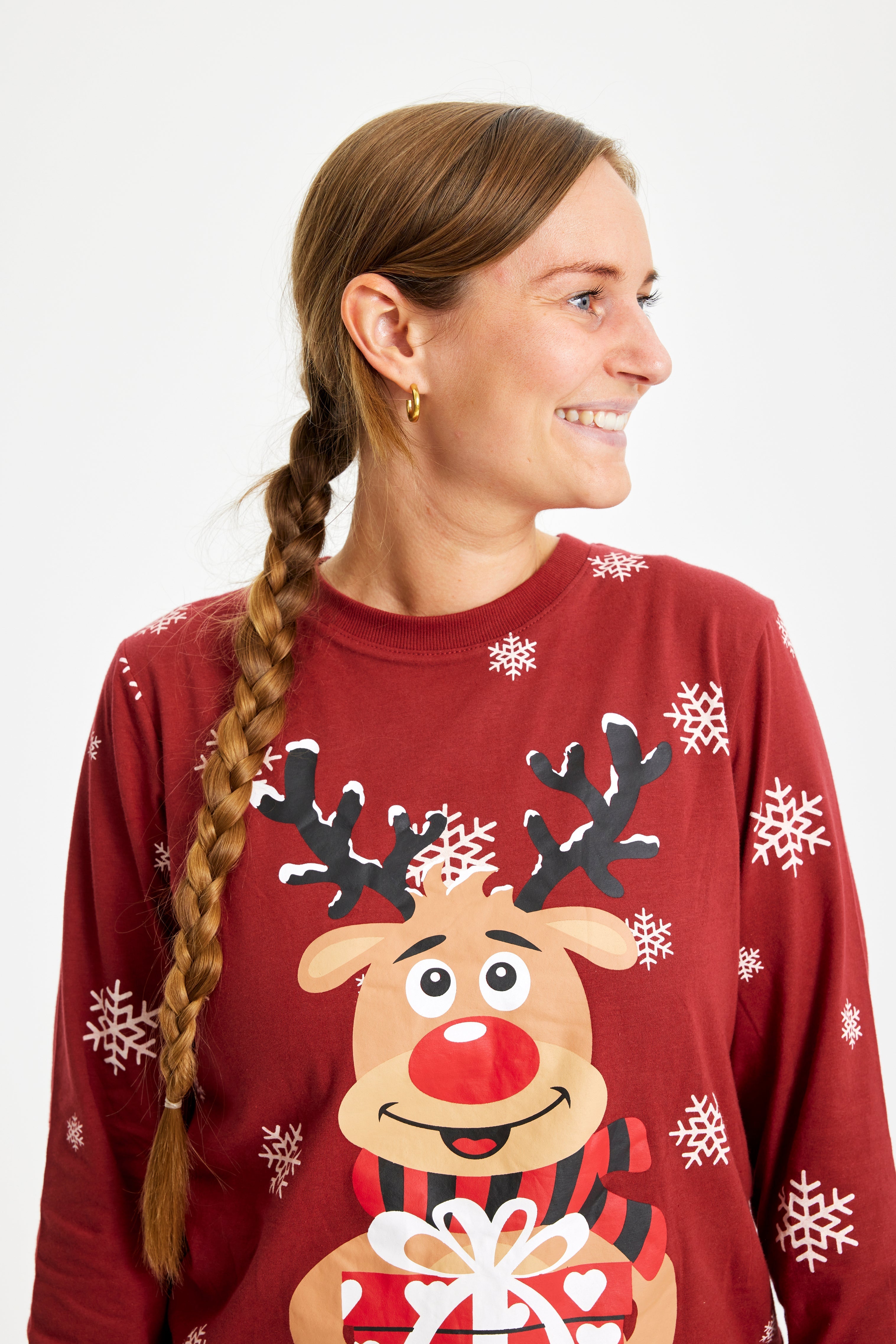 Ein posierender Mann in einem roten Weihnachtspyjama mit Rudolph.