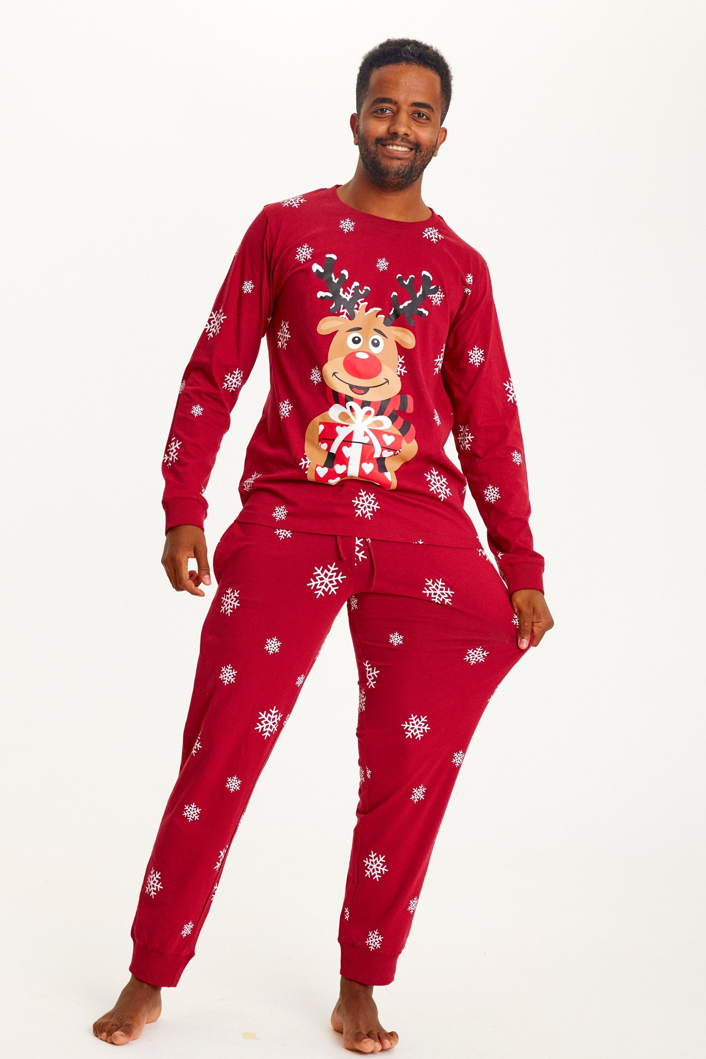 Ein posierender Mann in einem roten Weihnachtspyjama mit Rudolph.